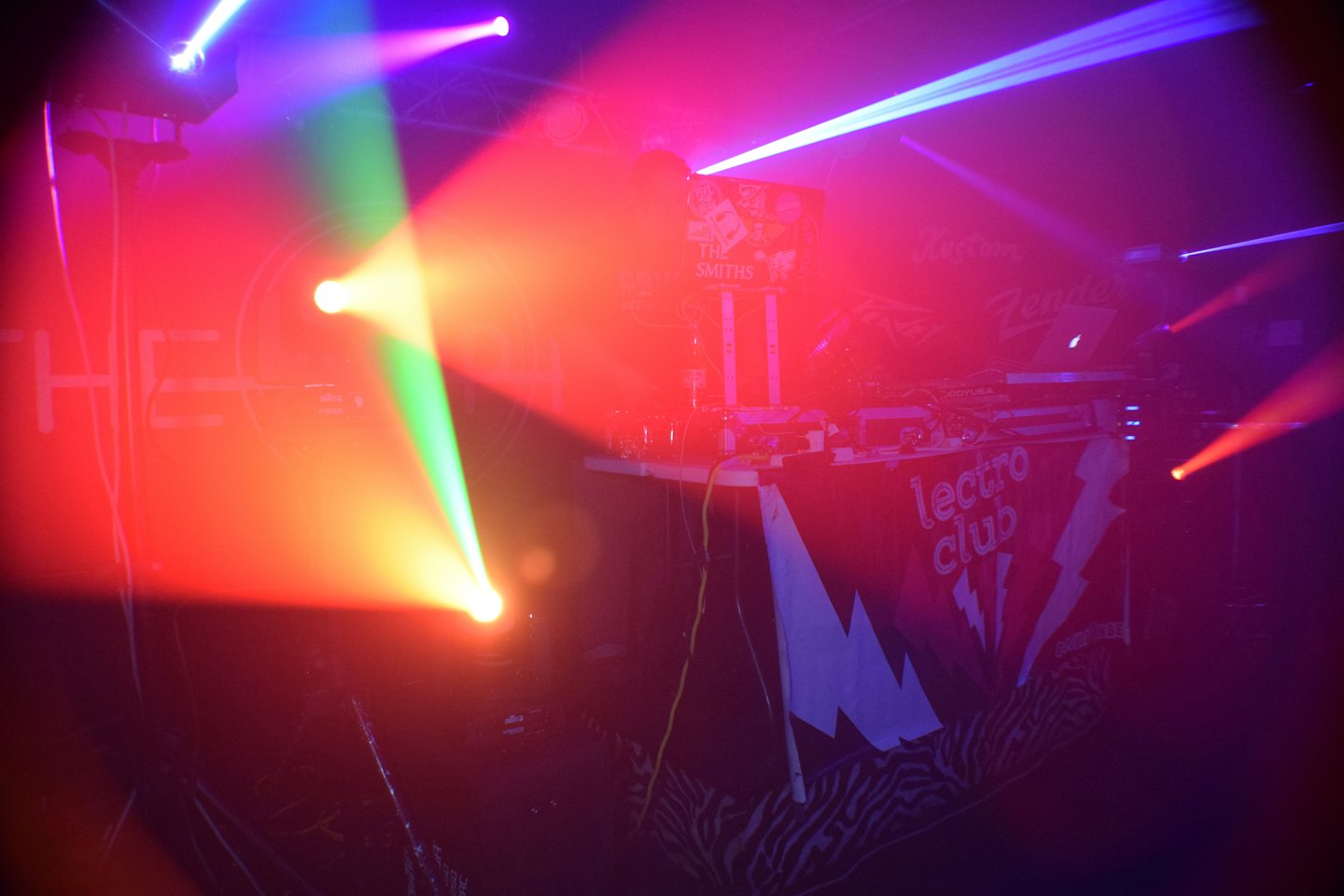 DJ equipment and laptop on a booth in a club.