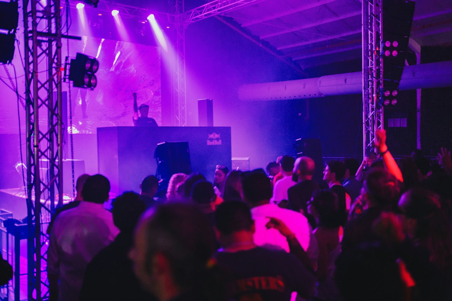 A crowd dances with raised hands at a music concert.